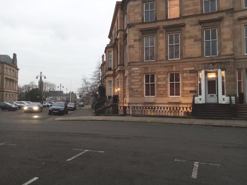 grand house in a crescent with park gates in
     background