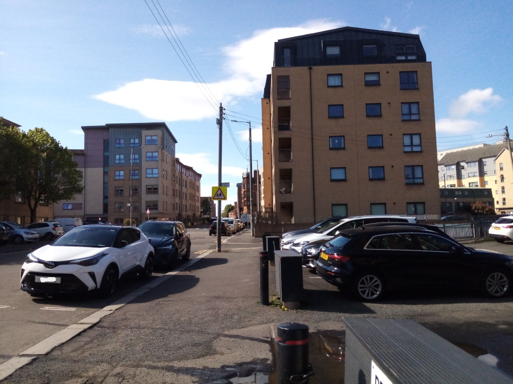 street heading into distance with car park in
     foreground