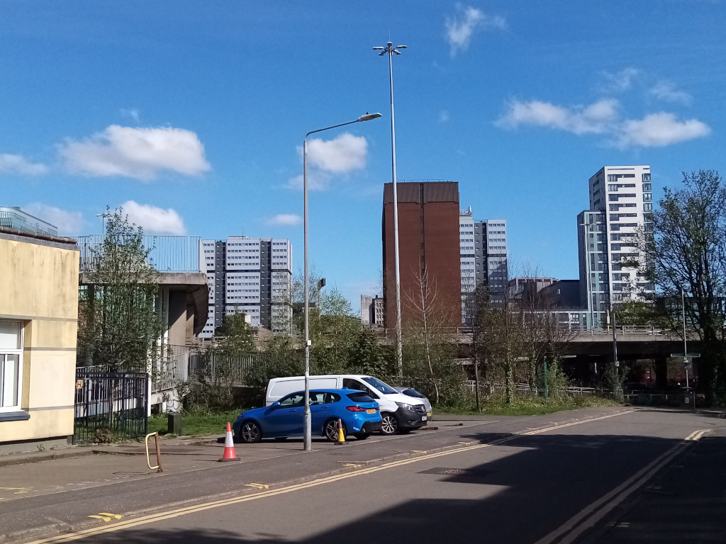 street scene with road bridge in middle distance and
     towers in background