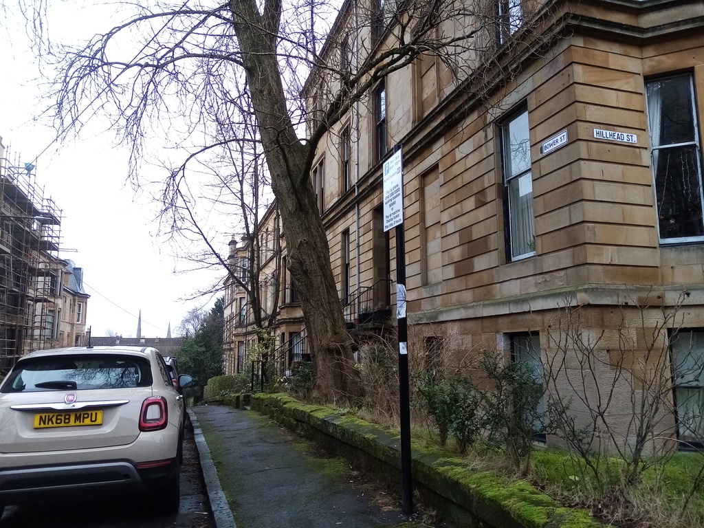 tenement building with high steps and large tree in
     front